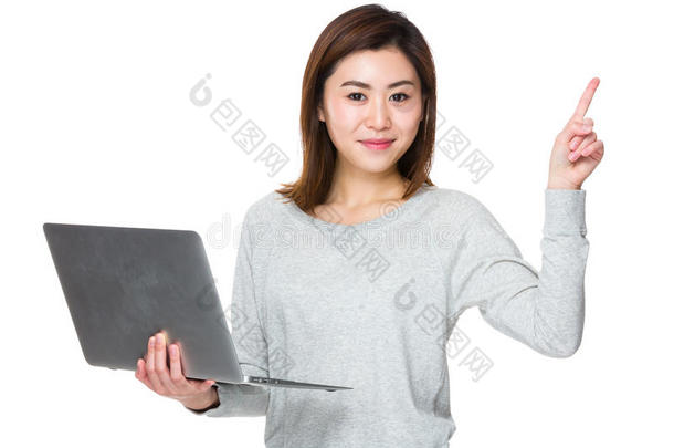 亚洲女人拿着笔记本电脑，手指指向上面