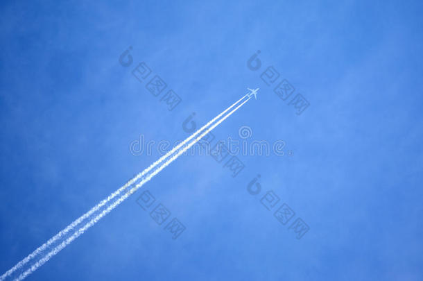 客机在晴朗的蓝天上飞行，留下白色的痕迹