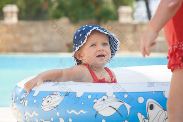 一个快乐的幼儿正在<strong>婴儿游泳池</strong>外面玩耍