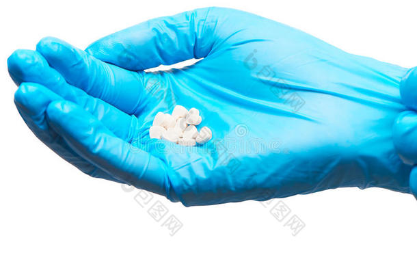 用蓝色消毒手术手套在女医生手上关闭一堆白色心形片