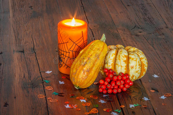 万圣节装饰品，点燃蜡烛和南瓜在木桌上