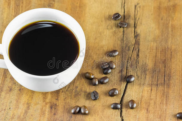 一杯咖啡和咖啡豆在木头背景上，温暖的色调