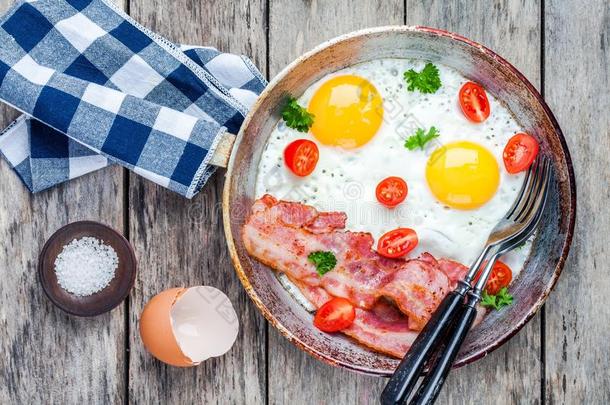 早餐有煎鸡蛋、培根、西红柿和欧芹