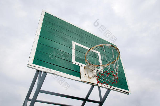 篮球圈-户外篮球圈和绿色背板，从底部的侧面看。 孤立在天空背景上。