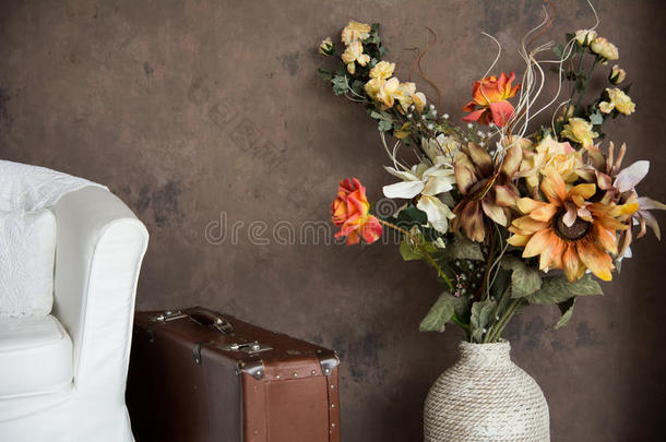 设计老式室内与花卉在花瓶手提箱和椅子