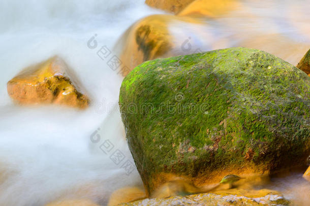 流动的水绕着金色的岩石