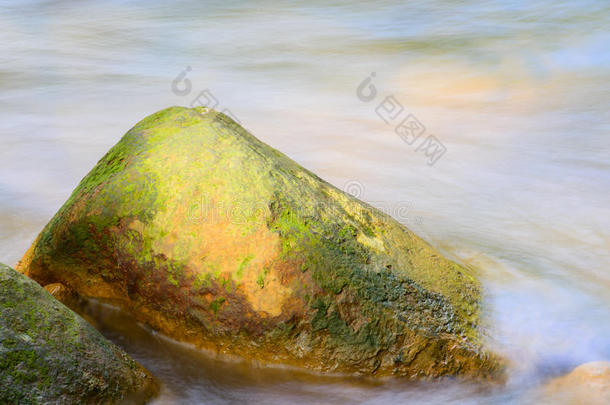 流动的水绕着金色的岩石