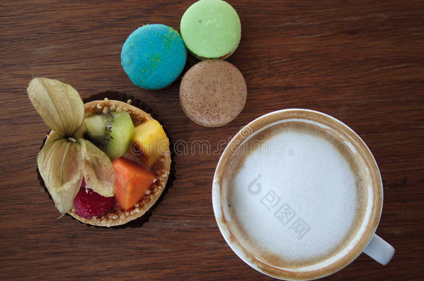 一杯热咖啡和水果馅饼和五颜六色的马卡龙在桌子上