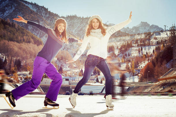 群有趣的青少年女孩在溜冰场户外滑冰