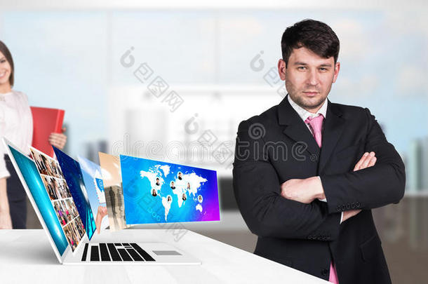 商人站在笔记本电脑附近，有许多屏幕。