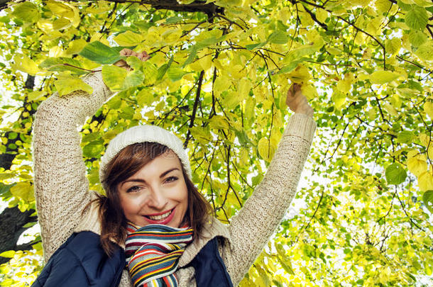 秋天，美丽微笑的黑发女郎在山毛<strong>榉树</strong>下摆姿势
