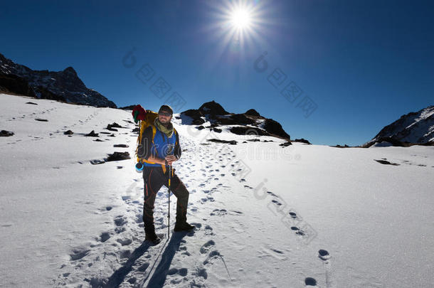 背包客登山者站立休息雪山。