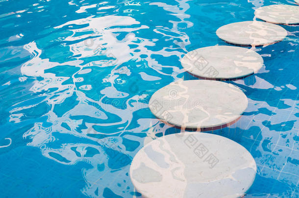 夏天有圆形装饰石的蓝色游泳池