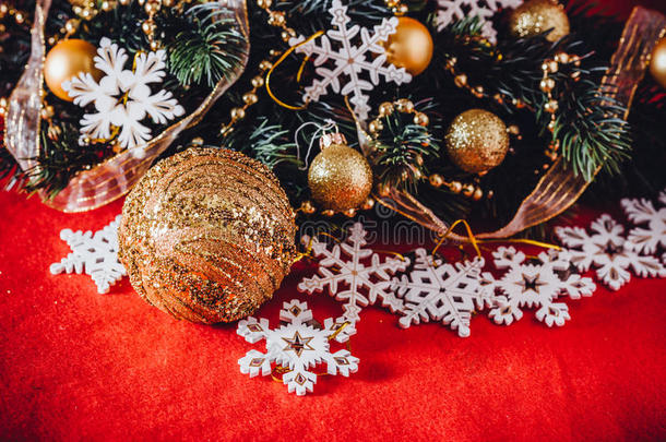 圣诞卡上有冷杉树枝，宝珠，花环和老式雪花在红色背景。
