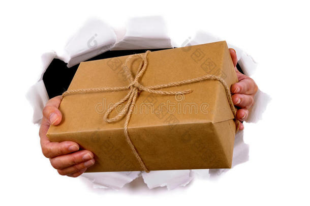 快递员或邮递员通过撕破的白纸背景递送或持有包裹
