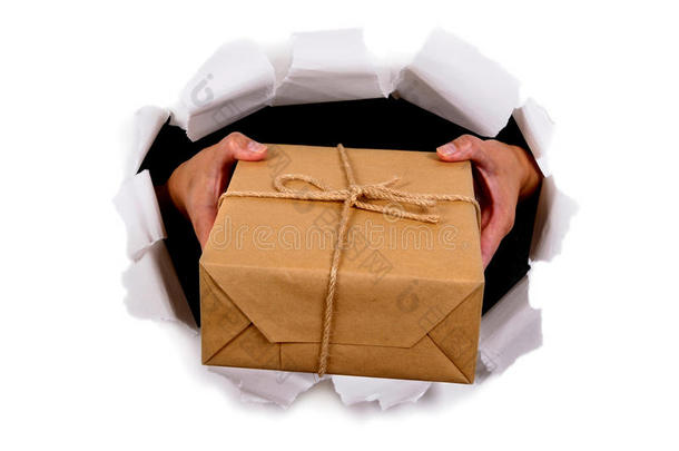 快递员或邮递员通过撕破的白纸背景双手递送或送小包裹