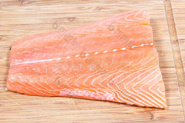 木制背景上的新鲜鲑鱼片。 欧米茄3脂肪酸的来源。