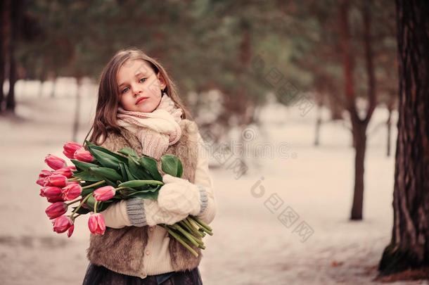 童女肖像与鲜花在舒适温暖的户外冬季散步