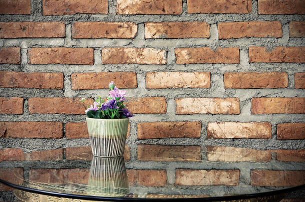 桌子上的<strong>花盆</strong>有<strong>玻璃</strong>砖墙背景。