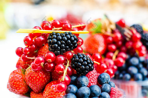 森林水果，如蓝莓，覆盆子，草莓，红醋栗在市场上。 在白色桌布上。 收获，农业