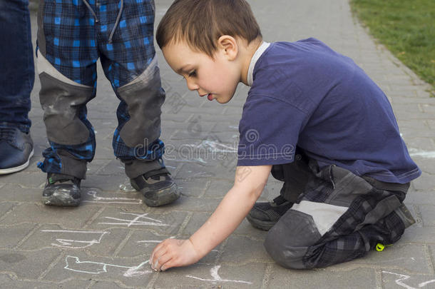 孩子用粉笔在人行道上画画