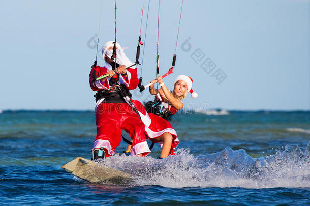 穿着圣诞老人服装的<strong>风</strong>筝上漂亮的年轻女孩和男人。 热带岛屿上的圣诞节和<strong>新年</strong>。 极端