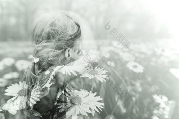 一个金发小女孩和春天草地的双重曝光图像
