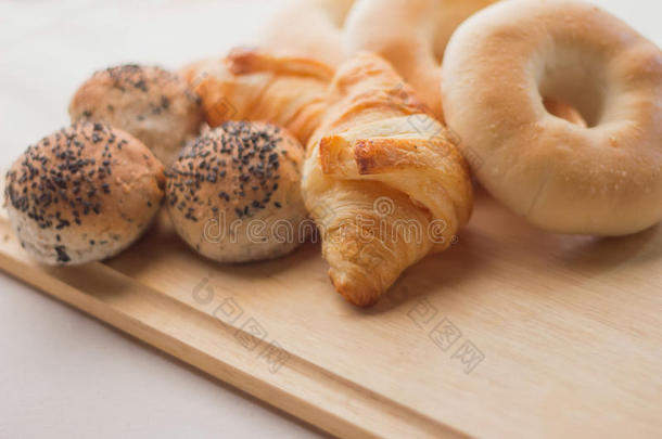 木板上的新鲜面包和白色背景