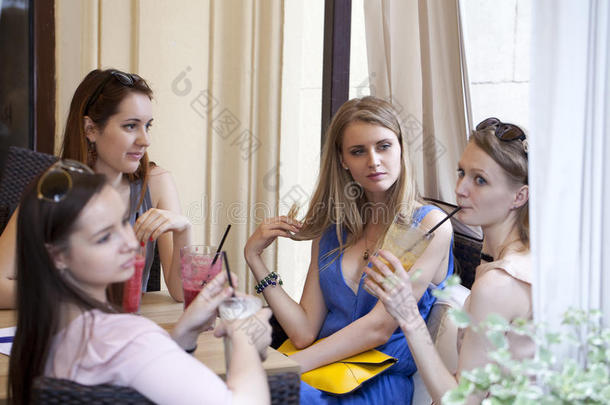 四个年轻女孩在夏天的咖啡馆里休息
