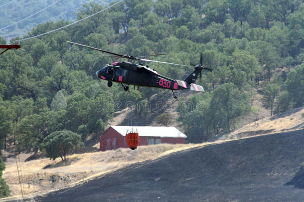 消防直升机飞越被烧毁的土地