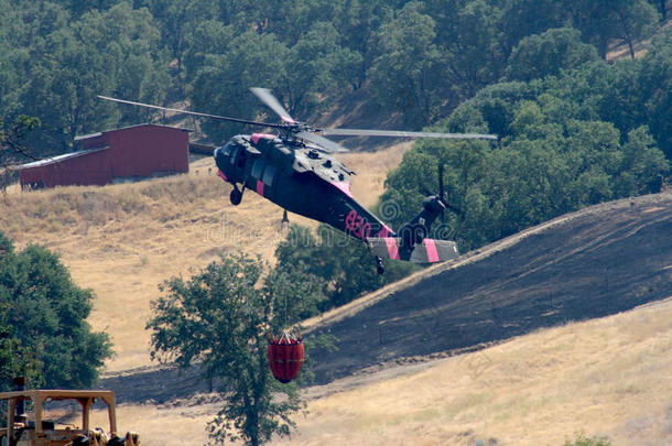 消防直升机飞越被烧毁的土地