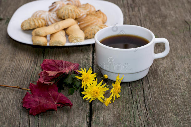 咖啡，树叶，小花和盘子后面有饼干，一种静物