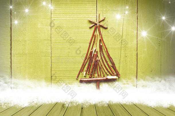 圣诞树是用木桌上桌子上的棍子排列在闪闪发光的绿色背景上的。 准备好产品展示蒙太奇