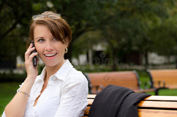 有吸引力的女人在公园里用手机说话