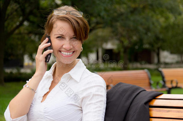 有吸引力的女人在公园里用手机说话