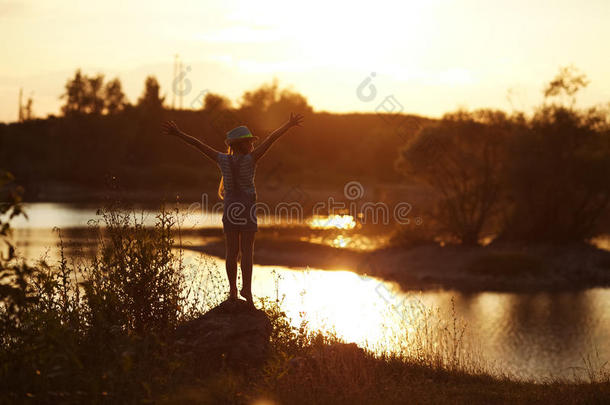 日落时，女孩站在河边