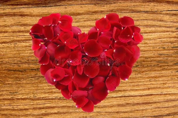 美丽的红色玫瑰花瓣作为木制心形符号