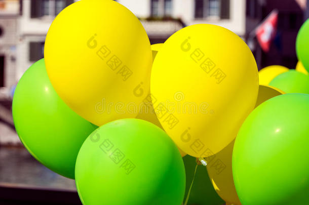 城市街道上明亮的黄色和绿色的气球