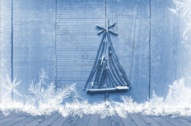 圣诞树是用木桌上桌子上的棍子排列在明亮的蓝色背景上的。 准备好产品展示蒙太奇