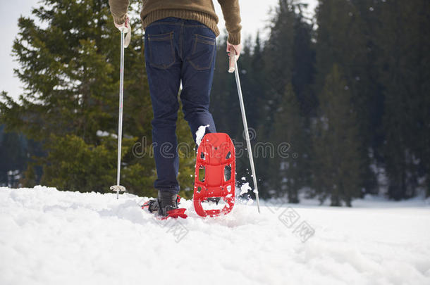 一对夫妇玩得开心，穿着雪鞋散步