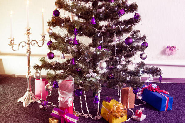 装饰圣诞树与周围的礼物和<strong>点燃</strong>的烛台