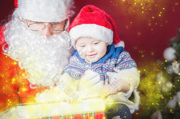 圣诞宝宝和圣诞老人打开礼物或礼品盒