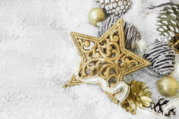 <strong>金色闪亮</strong>的圣诞装饰在雪中，带着优雅的丝带