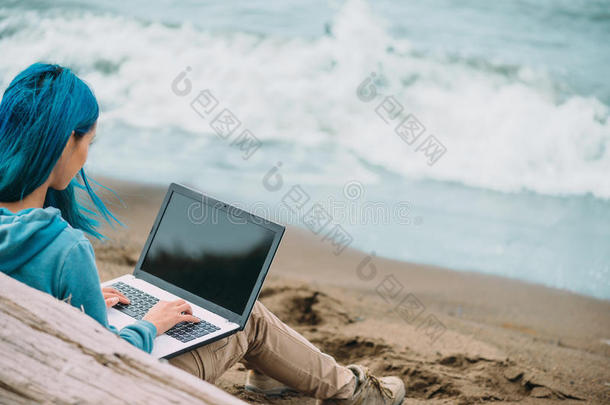 自由职业者女孩在海岸的笔记本电脑上工作