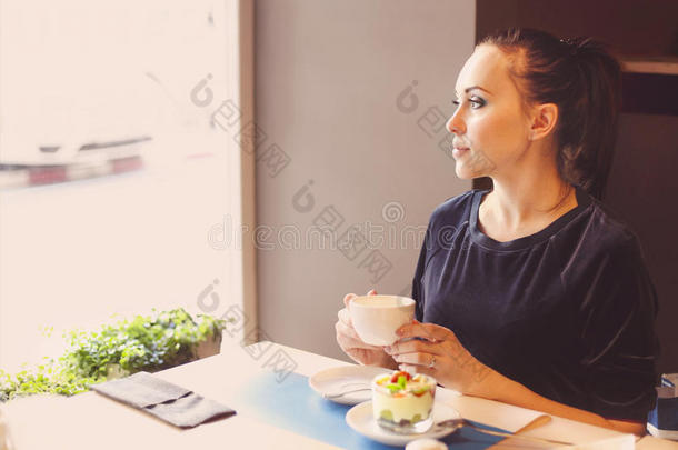 美丽的年轻<strong>女人</strong>在咖啡馆<strong>喝茶</strong>