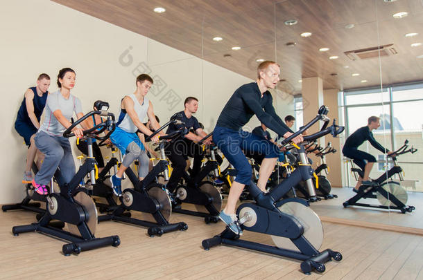 一<strong>群</strong>健身房的人在机器上，在课堂上骑<strong>自行车</strong>