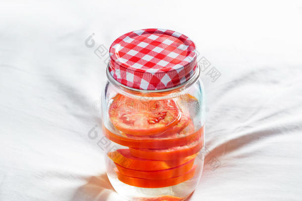 新鲜番茄在白色织物背景下的罐中解毒减肥水