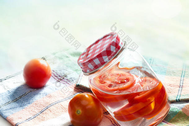 新鲜番茄在罐子中的<strong>排毒减肥</strong>水在织物粉彩上
