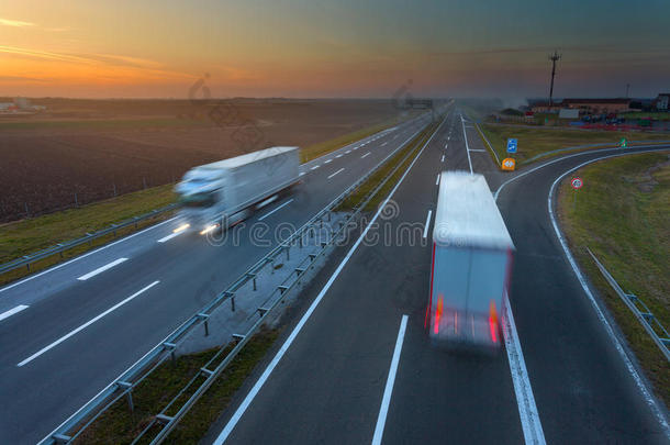 日落时，在高速公路上行驶的卡车模糊了