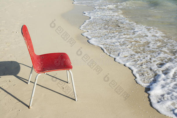 海滩上一张空的单人红椅子